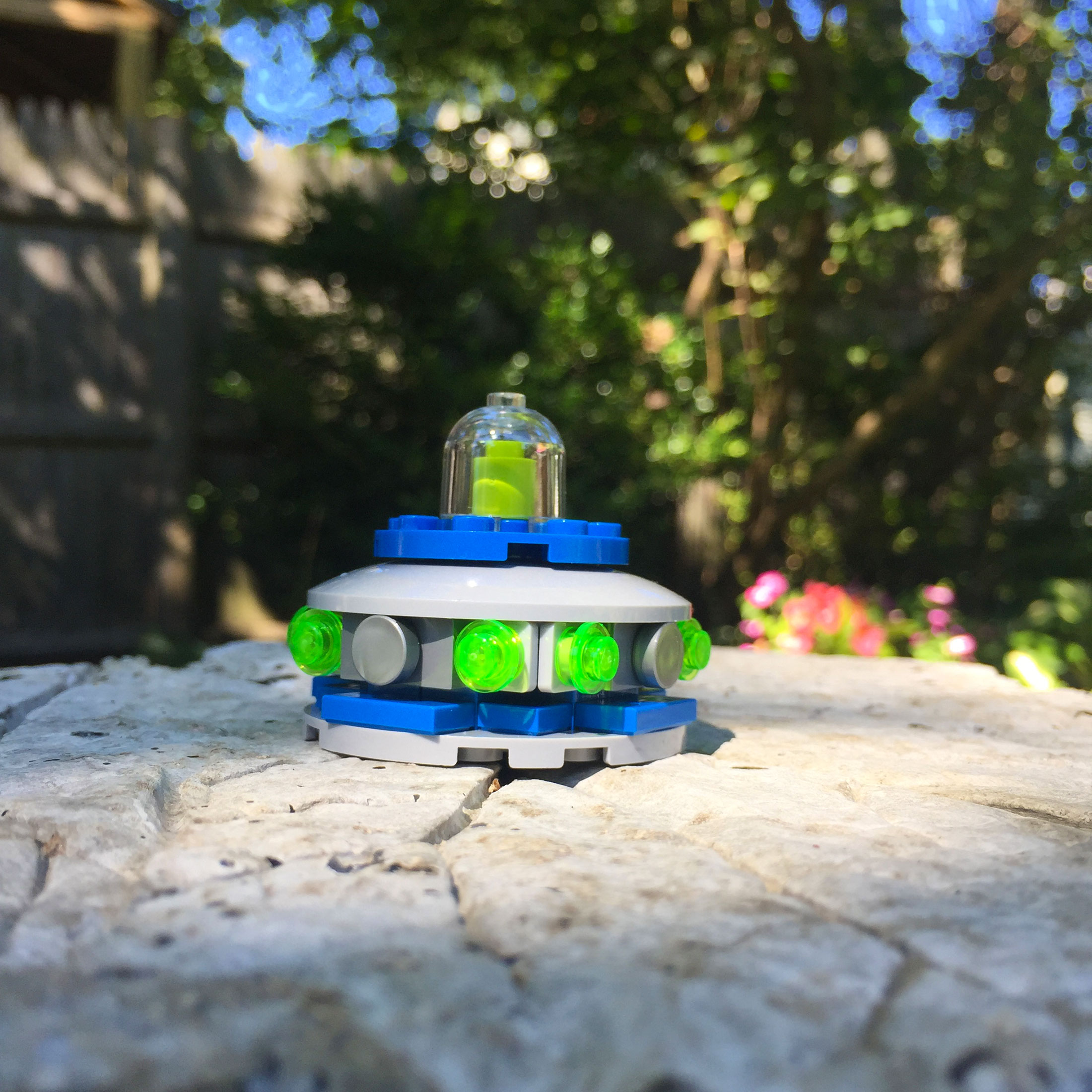 A UFO made of LEGOs with green character within the space ship.